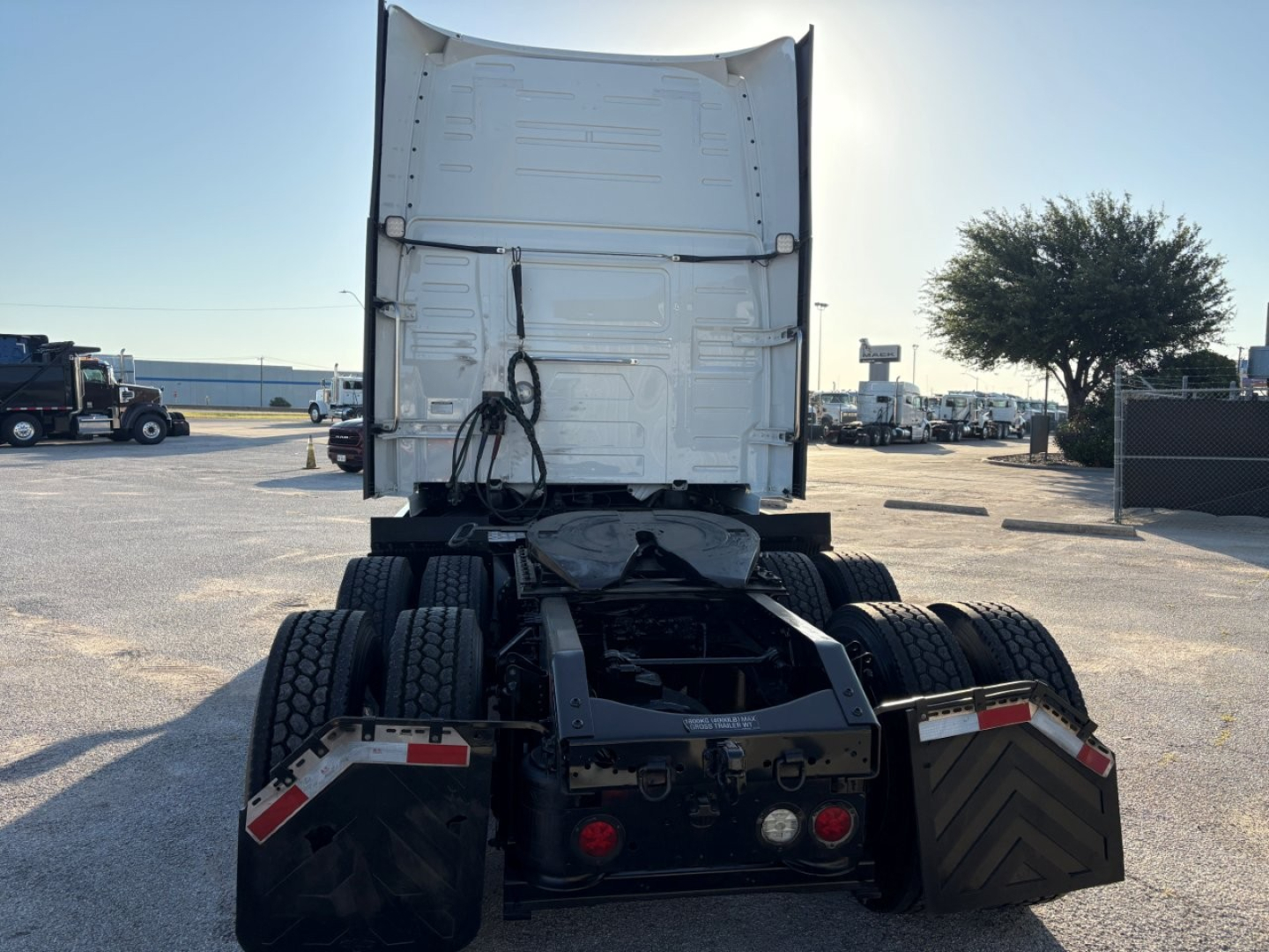 Volvo VNL64T860 semi truck rear view showing fifth wheel, dual rear axles, and tail sections with mud flaps and lights.