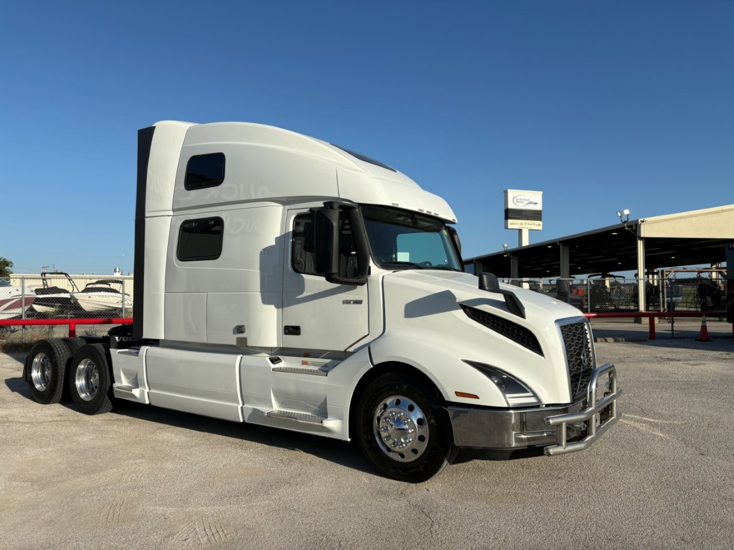 Volvo VNL64T860 sleeper cab truck side view showing white exterior, chrome front bumper, and dual rear axles.