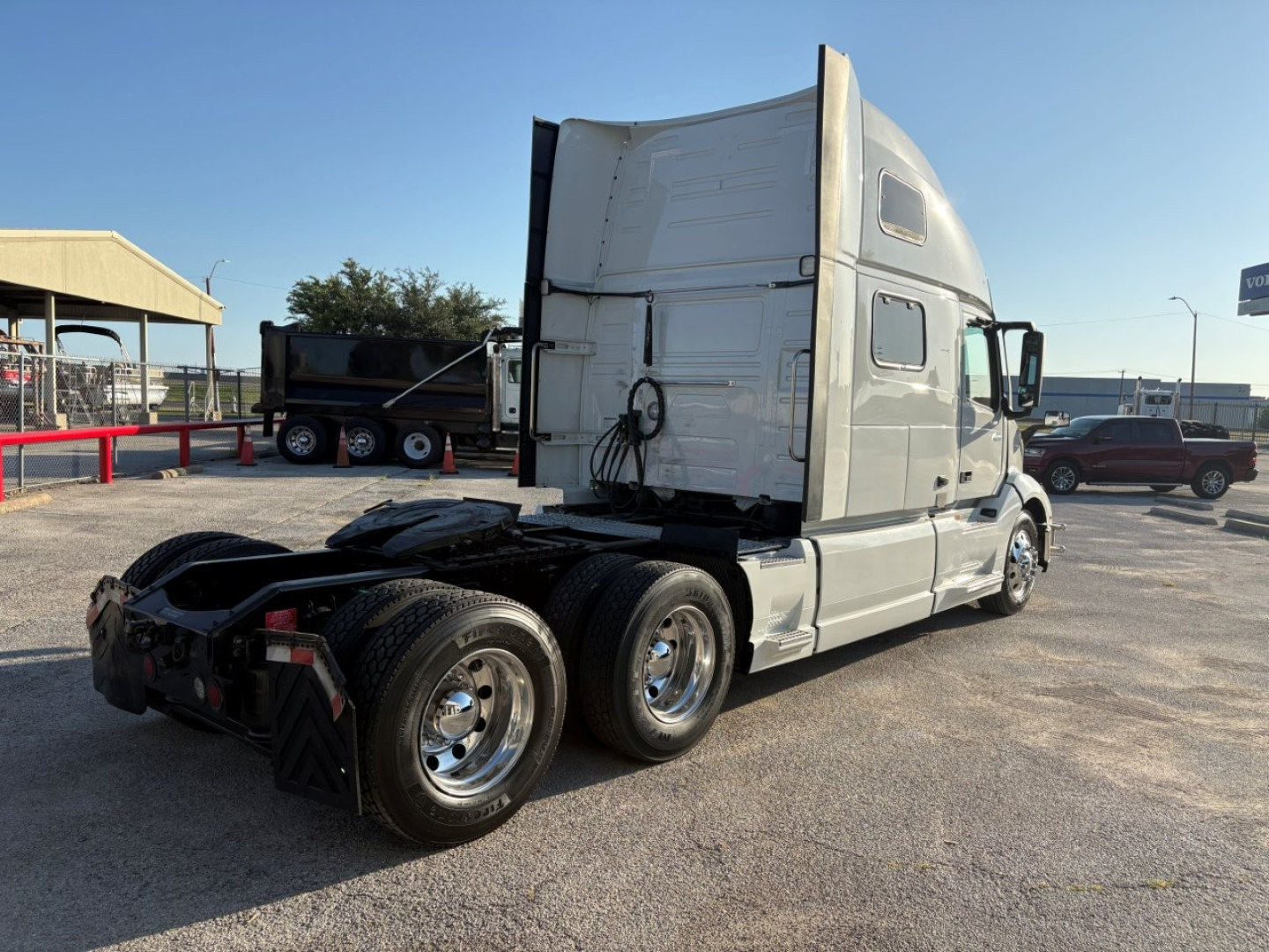 Volvo VNL64T860 truck from rear-right side showing sleeper cab, dual rear axles, chrome wheels, and fifth-wheel area.