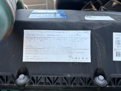 Label plate on Volvo engine bay with engine family PPM? 6/7? text. Visible stickers including Volvo logo and serial-like tags.