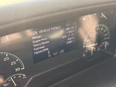 Volvo VNL dash showing Vehicle Totals with mileage, engine hours, time in service, fuel used, highest RPM; gauge cluster visible.