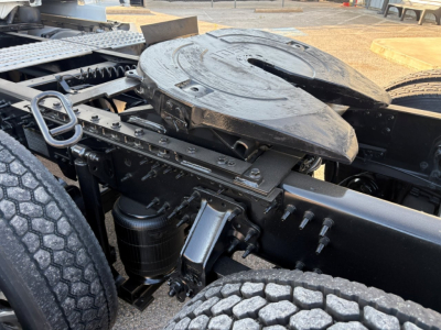 Volvo VNL64T860 drivetrain area showing fifth wheel mount and surrounding components, including air tanks, hoses, and chassis framing.