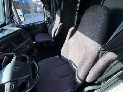 Volvo truck cab interior showing driver's seat and passenger seat with steering wheel and dashboard visible.