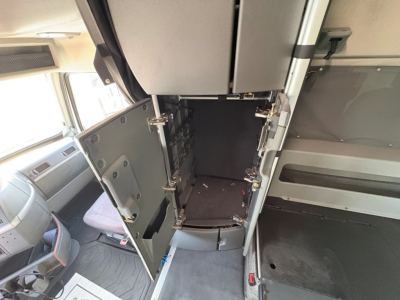 Volvo VNL64T860 interior showing open lower cabinet in sleeper area with storage compartments and dash area.