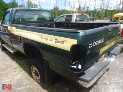 Dodge Ram 2500 pickup truck rear side view showing open bed and faded decals with 'DODGE' and 'FUNK...' along the tailgate and side stripe