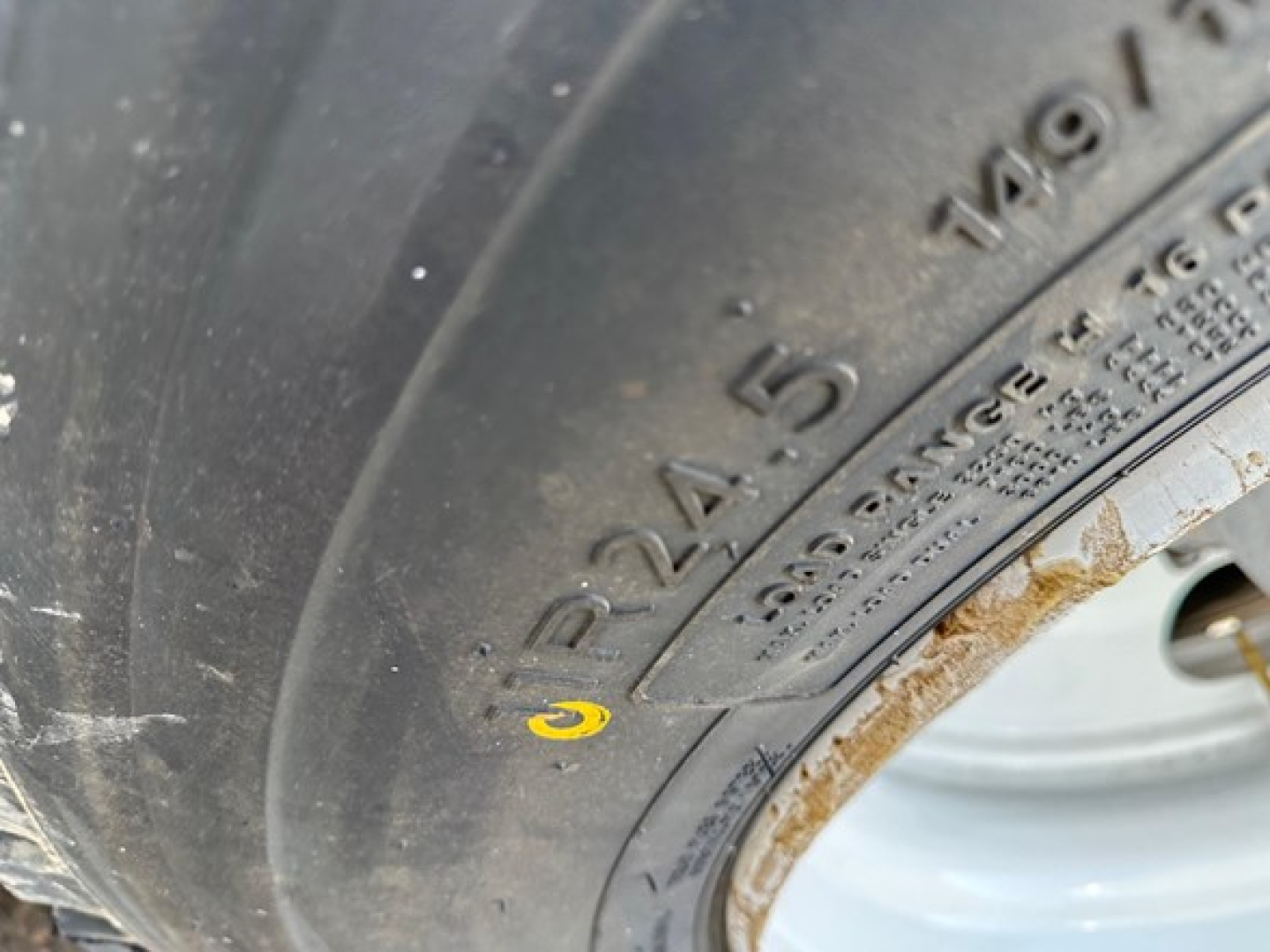 Ranco Ed26-34 dump trailer wheel and tire showing tire markings 275/80R22.5 and wheel rim with rusted edge.