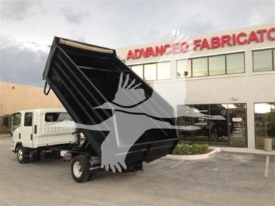 Dump truck bed on a new 14 ft Advanced Fabricators dump truck with raised hydraulic bed in front of dealership.