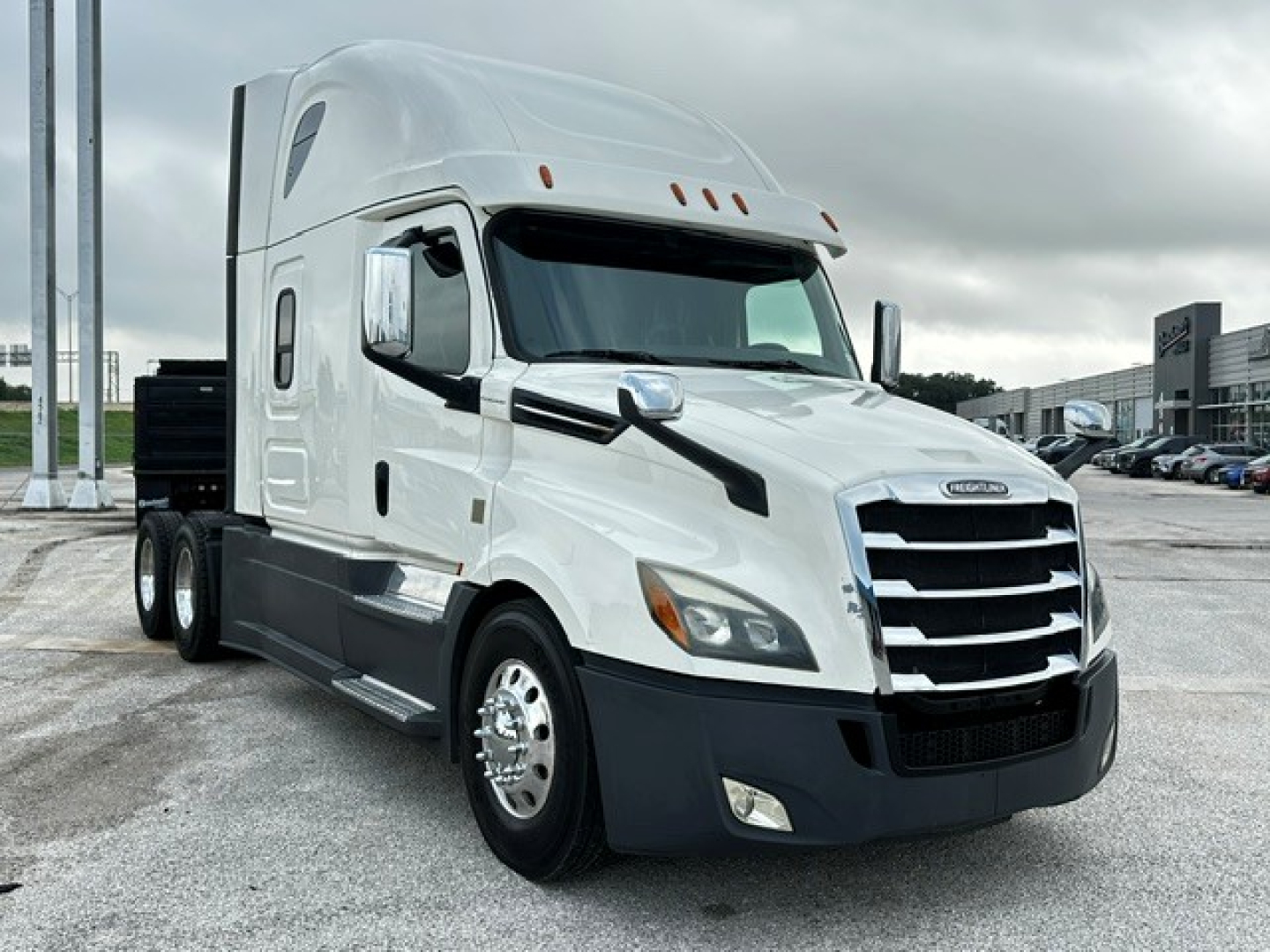 Freightliner Cascadia 126 truck in white view from front-left shows cab: chrome grille, dual headlights, side mirrors, and sleeper cab with aerodynamic design.