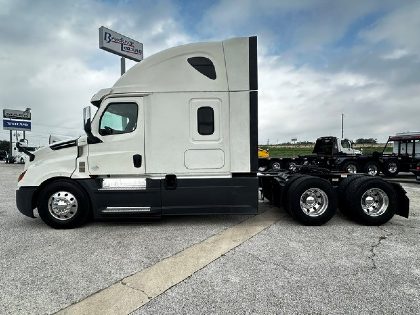 Freightliner Cascadia 126 sleeper cab side view showing tractor tractor with white cab and black lower panels, 6-wheeled rear, no trailer.
