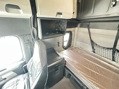 Cab interior of a 2019 Freightliner Cascadia 126 showing sleeper area with a brown mattress, overhead storage, and side panels.