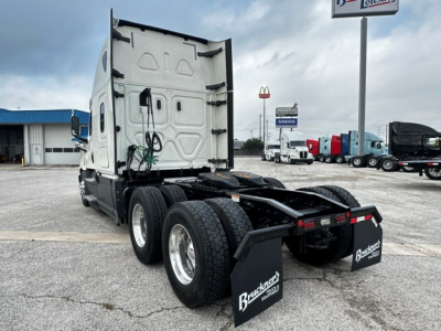 Conv sleeper cab tractor showing rear view and fifth wheel, two rear axles, mud flaps with Brickner's logo, white cab interior visible, Freightliner Cascadia 126 used truck.