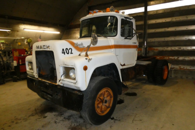 Mack R690T cab and chassis truck in a workshop; white body with orange stripe and wheels; number 402 on grille; diesel livery.