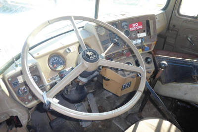 Mack R690T cab interior showing steering wheel, gauges, and gear lever with No Smoking sign on dash.