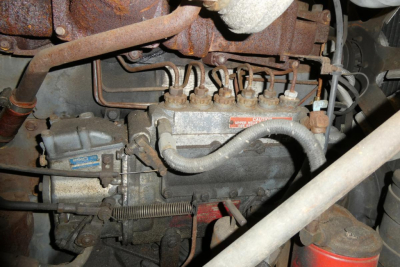 Mack R690T engine bay view showing diesel fuel lines, intake manifold, and turbo components.