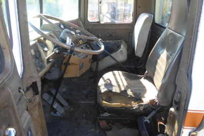 Mack R690T truck interior showing steering wheel, vintage dash, and worn driver seat in-service condition.