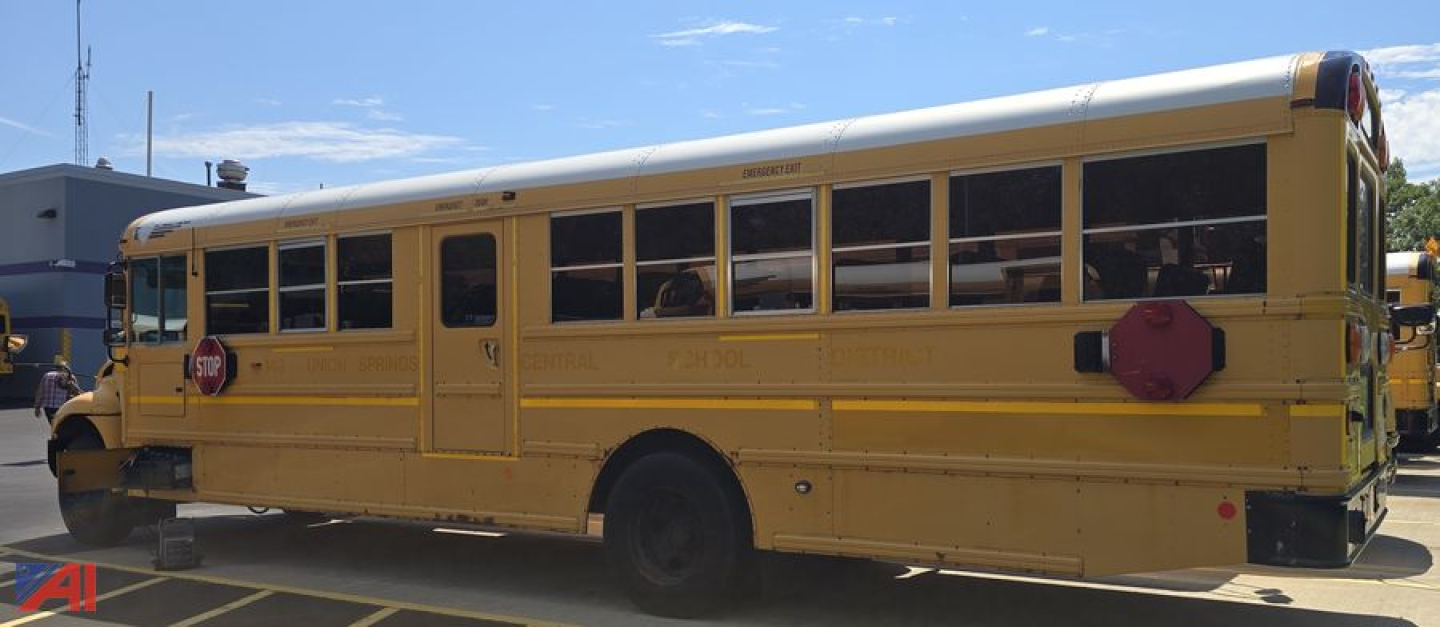 School bus side view showing elongated body with multiple windows, yellow body, black tires, rear emergency exit door, and star-shaped red reflectors.