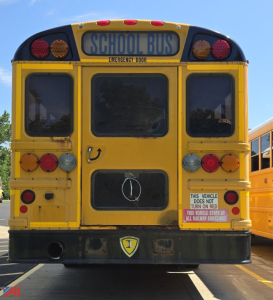 Back view of a yellow IC Corporation International B2 CE school bus showing rear emergency door, lights, and a small bumper shield.