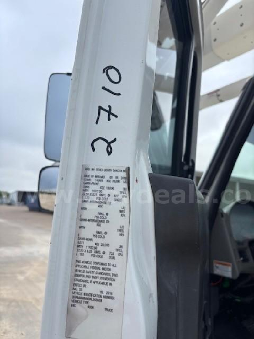 Truck cab door frame with a close-up of a metal data plate containing vehicle specs and a handwritten 01-20 on the door jamb.