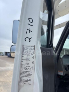 Truck cab door frame with a close-up of a metal data plate containing vehicle specs and a handwritten 01-20 on the door jamb.