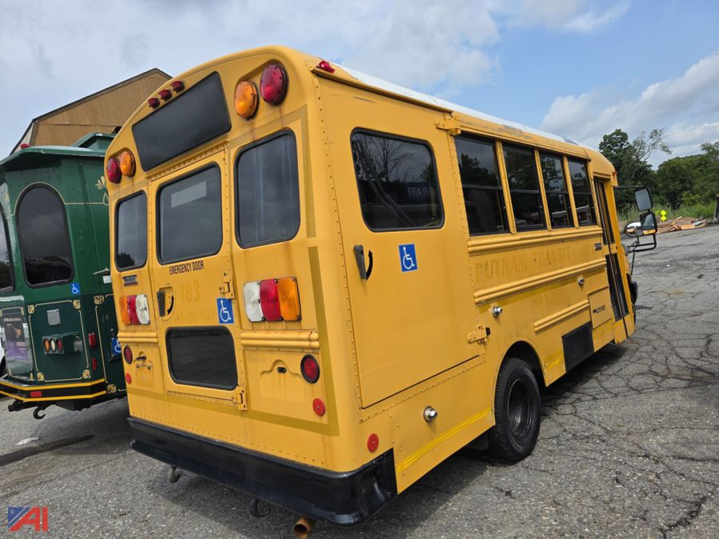 Yellow school bus rear-left view showing taillights and wheelchair accessibility sticker, 2012 Chevrolet Express School Bus
