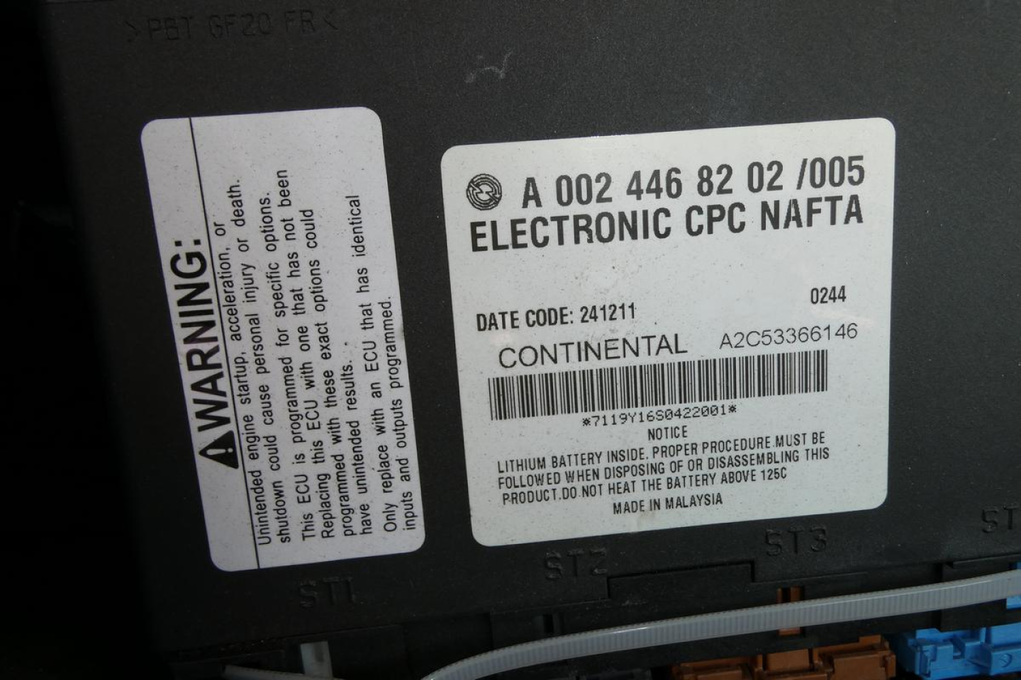 Electronic NPC label and warning sticker on truck battery area showing A A0024468202005 ELECTRONIC CPC NAFTA and Lithium battery warning; date code 241211; CONTINENTAL 2A653366146.