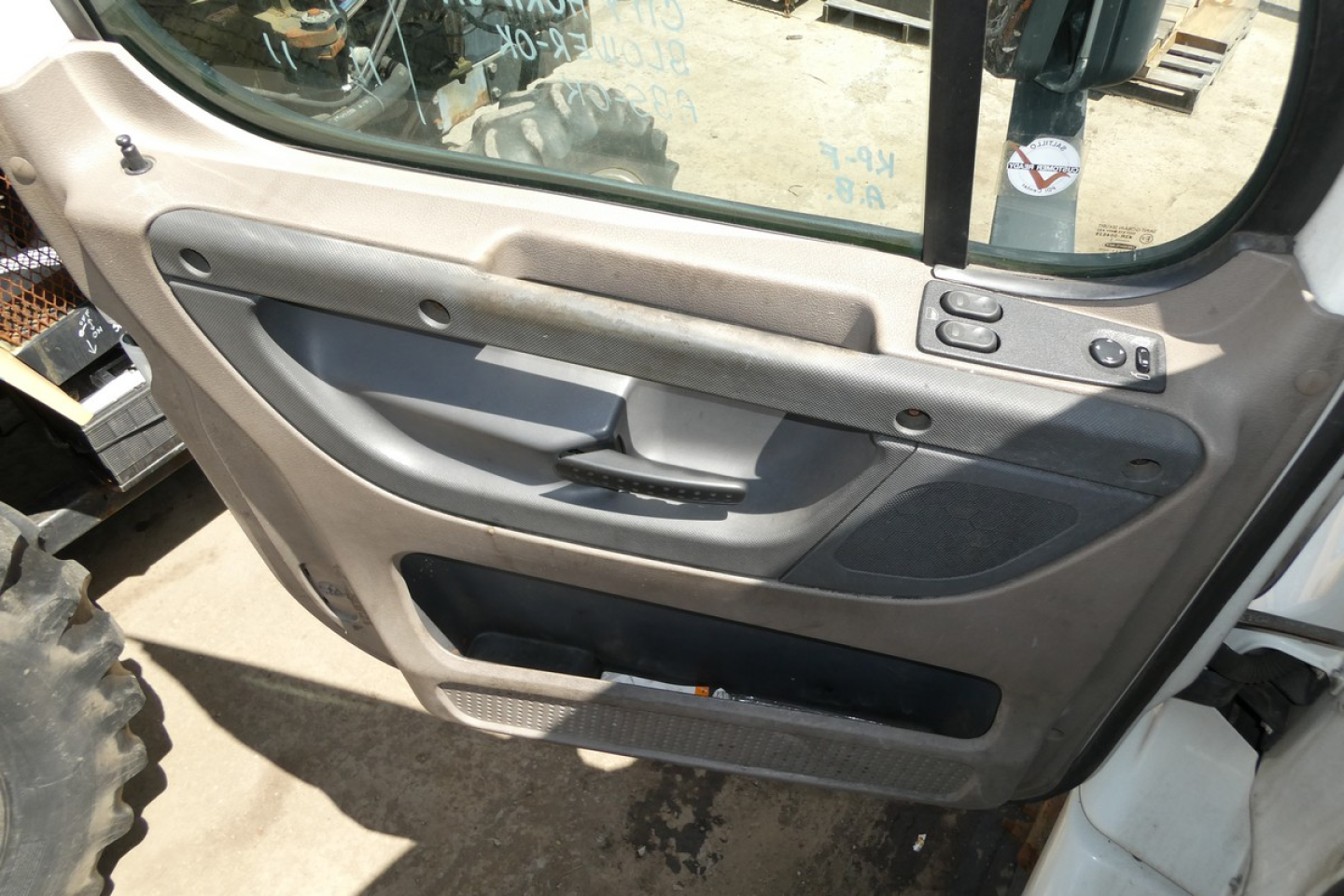 Freightliner Cascadia 113 door panel view showing interior window controls and storage pocket.