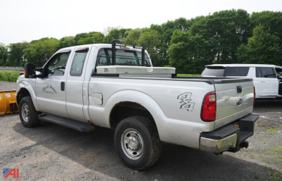 Ford F-250 pickup truck with 4x4 badge visible on rear quarter panel, dual rear wheels, aluminum toolbox in bed, and utility rack on cab; no other legible text seen.