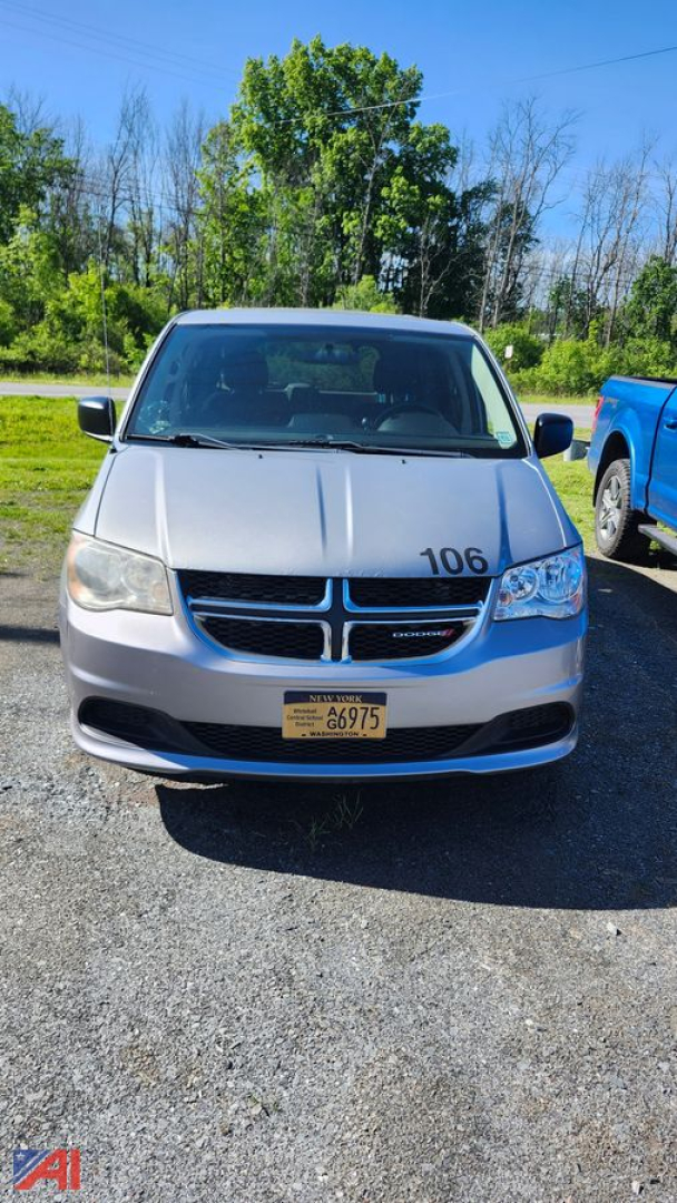 Dodge Grand Caravan front view showing grille and headlights with number 106 on hood and yellow license plate.
