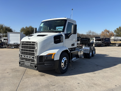 Truck front and side view showing Mack AN64T conventional daycab with white cab, black grille, and dual rear axles. Visible text includes MACK on the grille and VIN/stock numbers not on the vehicle.