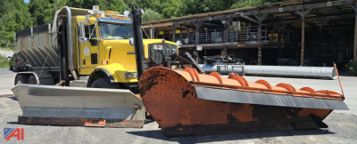 Front view of a yellow Kenworth T800 dump truck with attached orange snow plow blade in a yard.