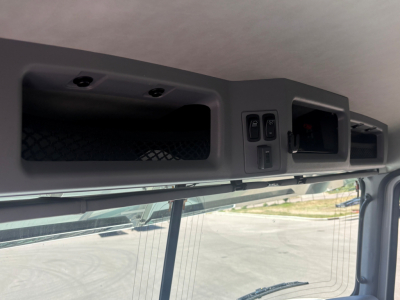 Cab interior overhead controls panel and storage, with two rectangular vents and switch panels.