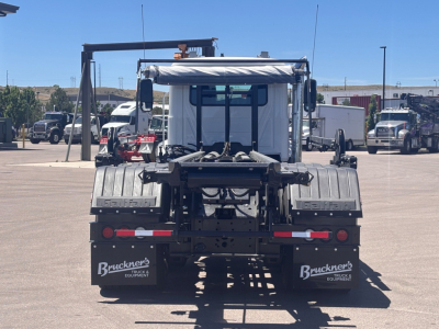 Mack GR64B truck rear view showing roll-off chassis and mud flaps with Bruckner's equipment logos.
