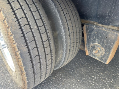 Tractor-trailer wheel and side of deck showing dual tires and undercarriage rock guard on a Transcraft DTl trailer.