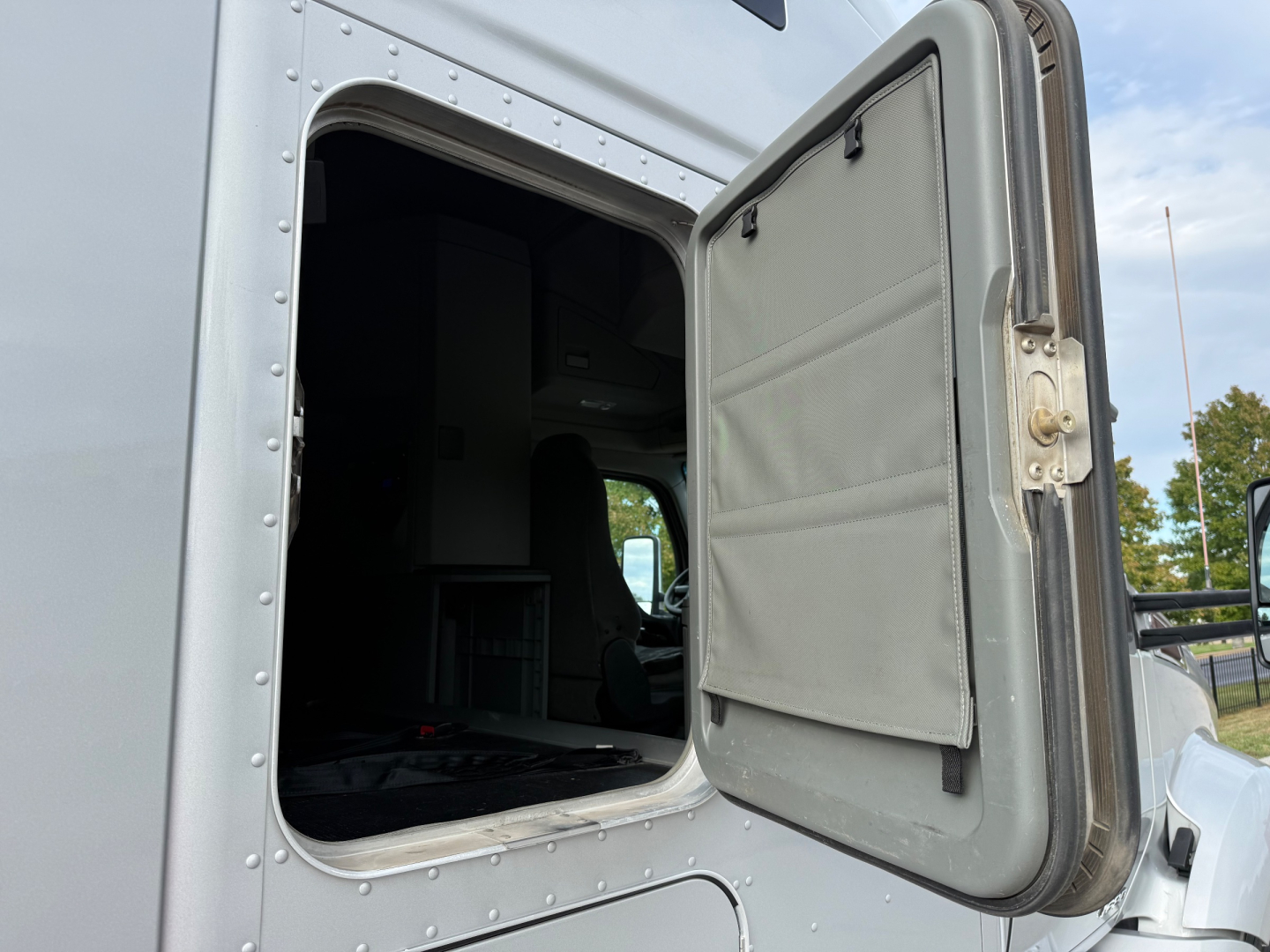 Kenworth T680 cab open-side exterior showing side access door and bare interior.
