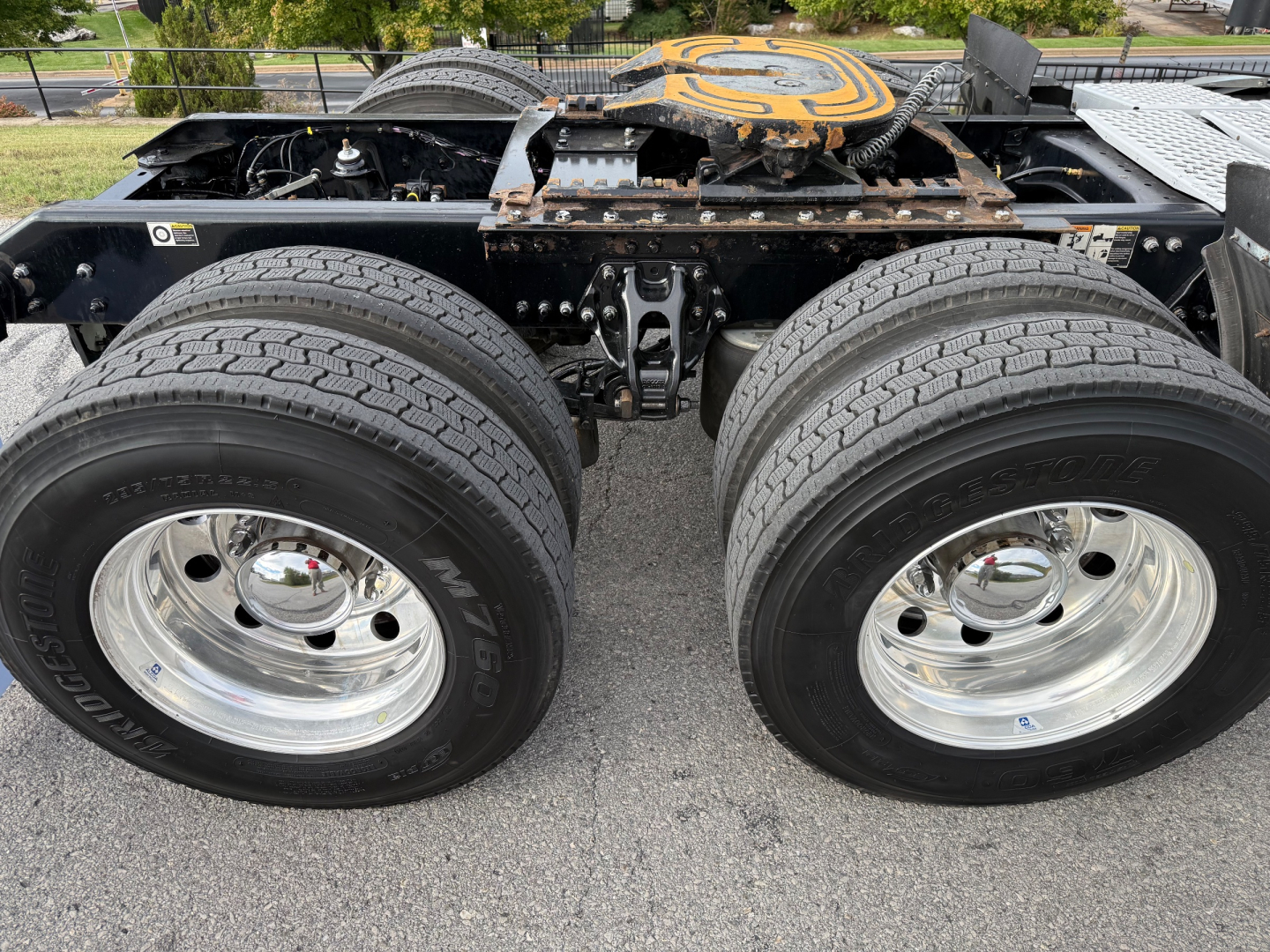Kenworth T680 chassis with dual rear axles and wheel rims visible, showing tires and suspension components under the cab.