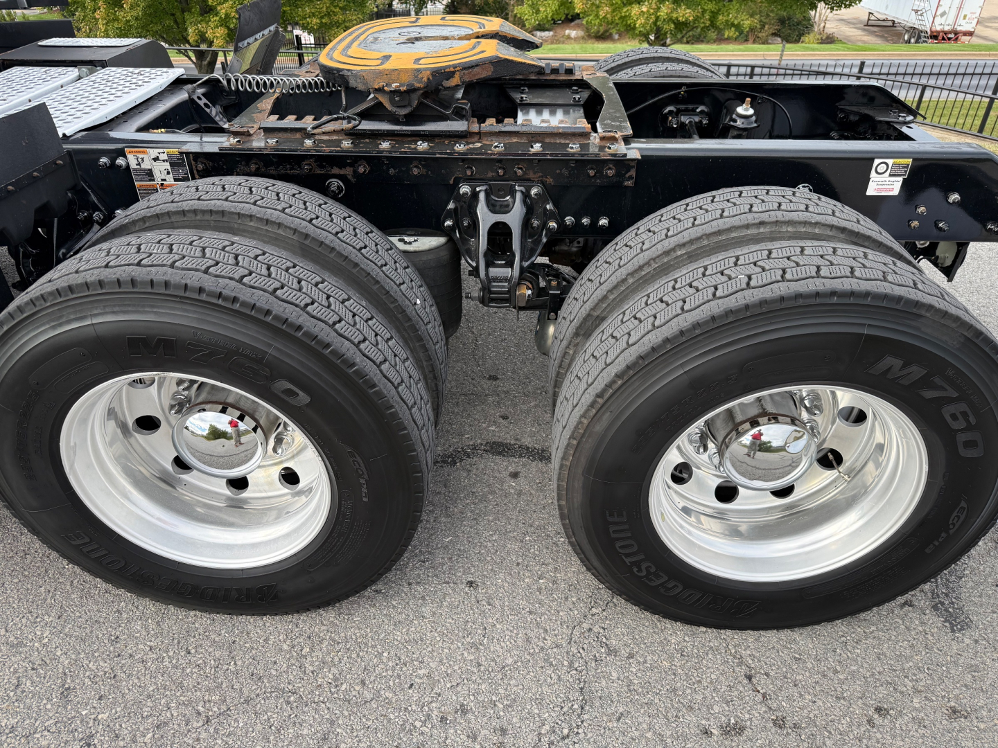 Kenworth T680 chassis showing dual rear wheels and undercarriage components with chrome wheels and tires.