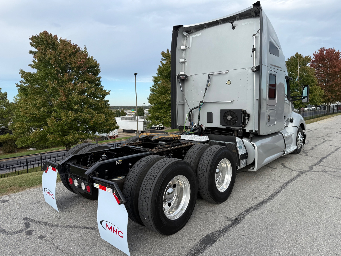 Kenworth T680 tractor rear view showing fifth wheel, dual rear axles, and sleeper cab with window.