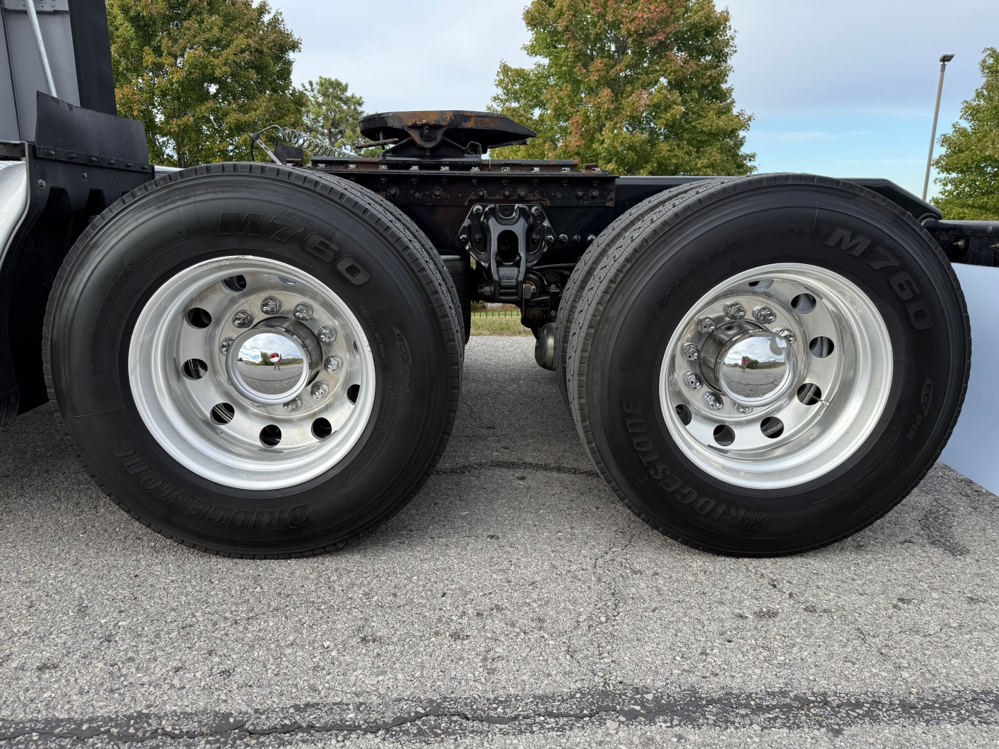 Dual rear wheels of a 2021 Kenworth T680 chassis showing chrome hubcaps and tires with visible rims. No visible text on tires or frame.