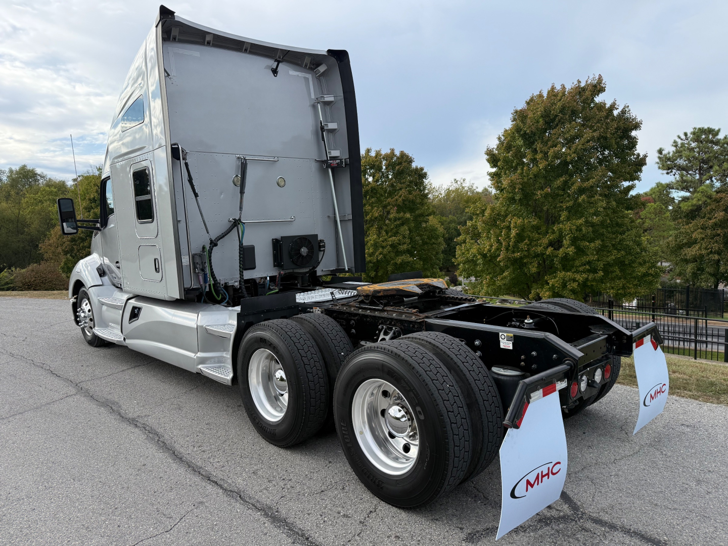 Kenworth T680 tractor rear/side view showing dual rear axles, fifth wheel area, and sleeper cab with vertical exhaust and rear mud flaps.