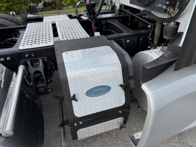 Kenworth T680 engine bay area showing aluminum diamond plate toolbox/step along with surrounding chassis components.