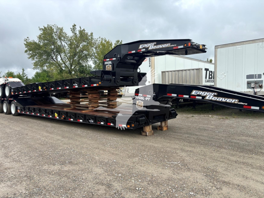 Eager Beaver 35Gsl-S lowboy trailer with telescoping gooseneck stacked on top of another section, black with white and red logos reading 'Eager Beaver' on the gooseneck and frames.
