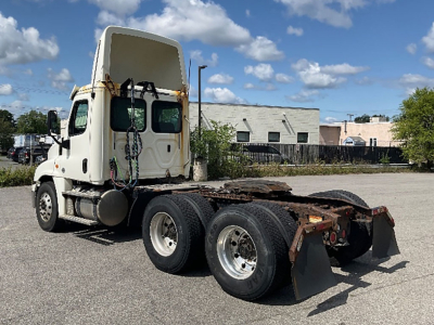 Truck chassis with tractor cab, 2018 Freightliner Cascadia125, side view showing rear dual axles and fifth-wheel area, clear sky.