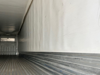 Trailer interior side wall and ribbed floor of a 2022 Utility Reefer trailer showing white insulated interior and cargo area near rear door.