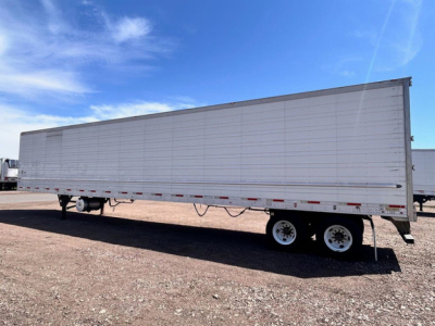Trailer side view showing a 2022 Utility refrigerated trailer with white panels and dual-axle wheels.