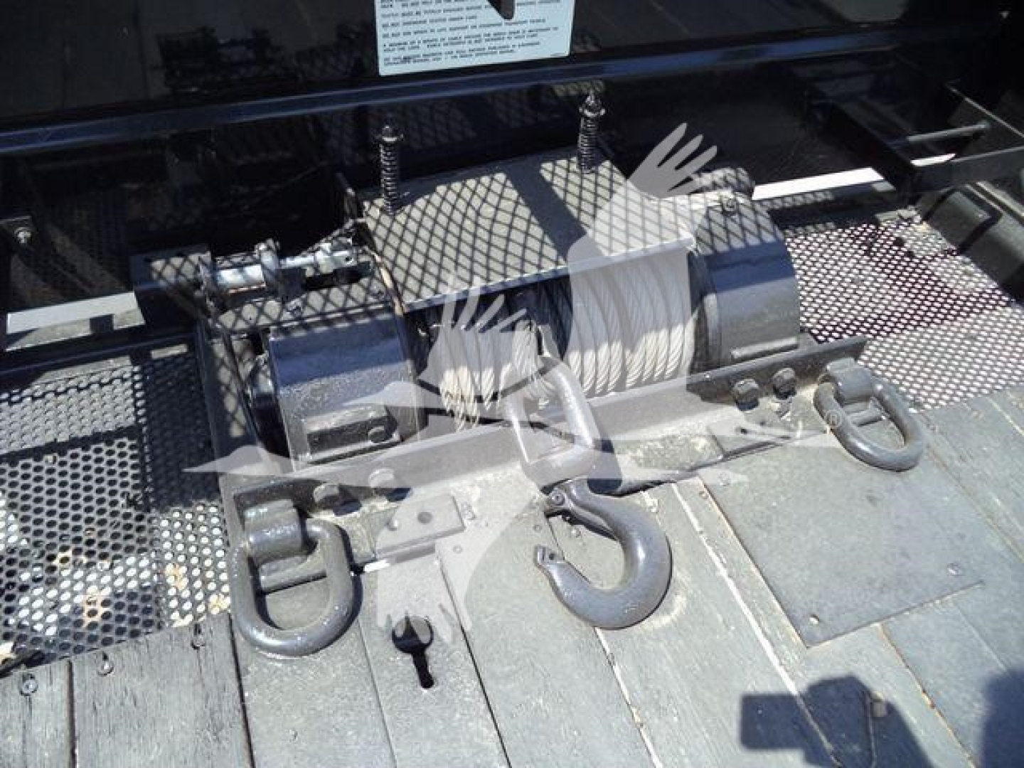 Roll-back equipment mounting on truck deck with winch and hooks visible.