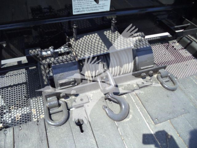 Roll-back equipment mounting on truck deck with winch and hooks visible.