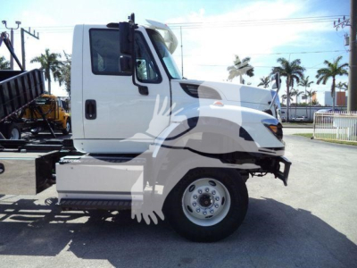 Truck cab side view with International Workstar badge not visible; showing bold white truck cab, front wheel, and bumper.
