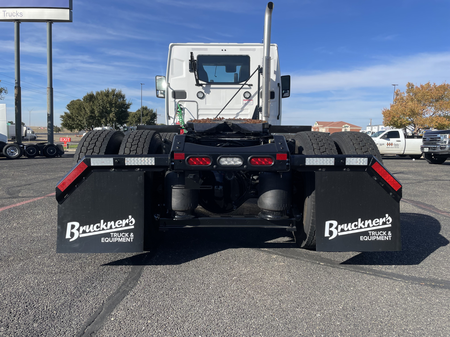 Mack PR64T rear view showing large mud flaps with Bruchner's Truck & Equipment logo, dual rear tires, and fifth-wheel connection area.