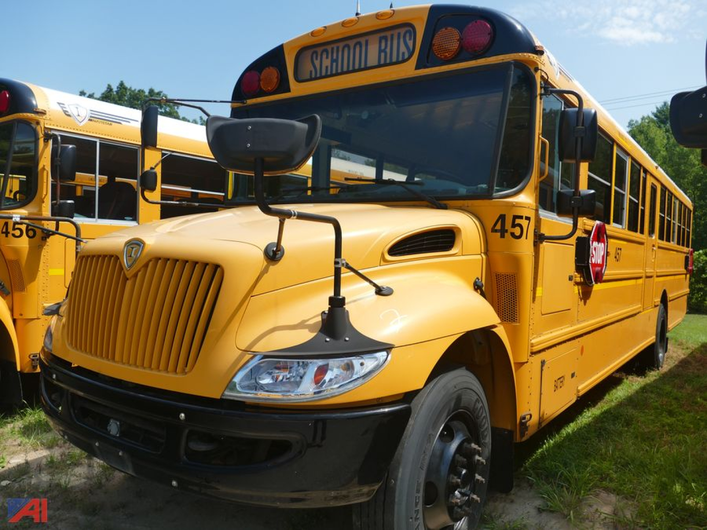 School bus showing front left view of a 2019 International CE 3000 with yellow exterior and STOP sign; bus number 457 visible.