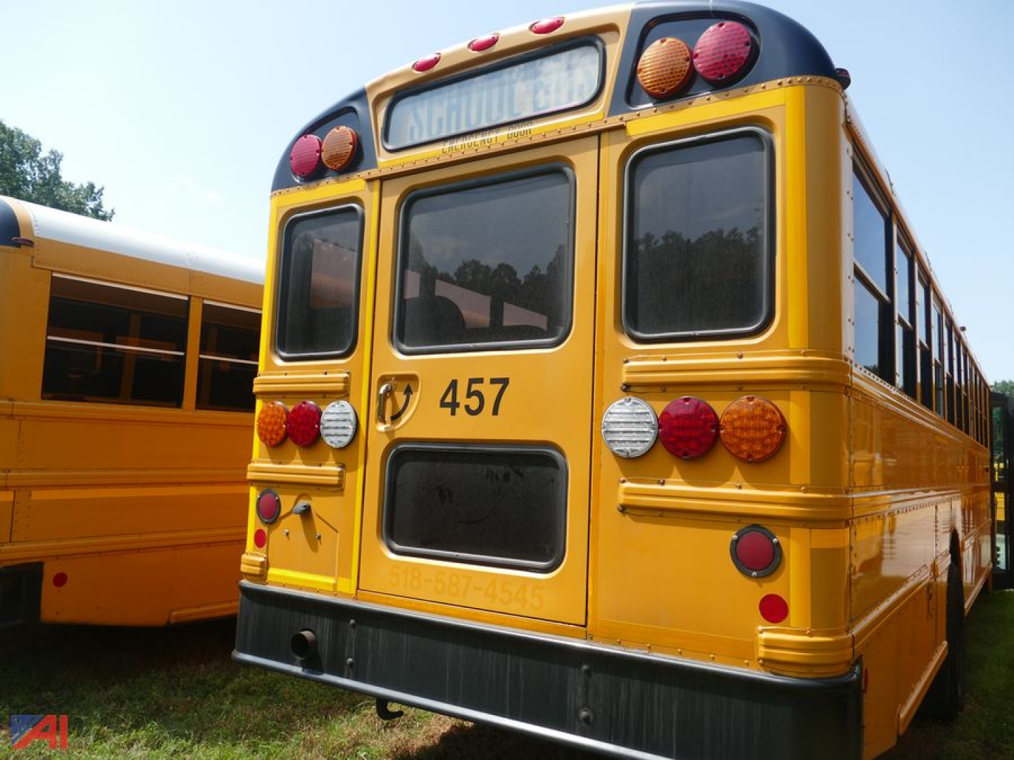 School bus rear view showing number 457 and taillights in yellow bus with windows